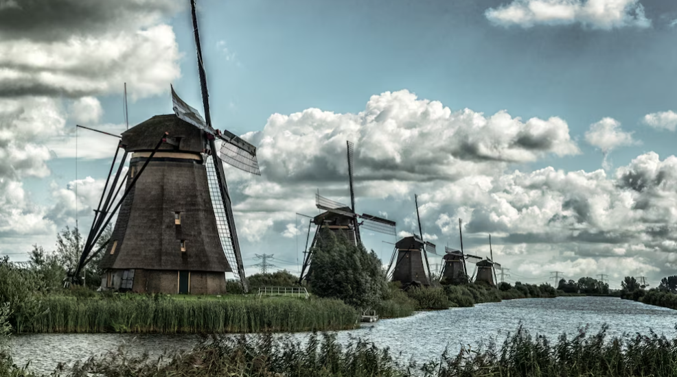 windmills near the lake under the cloudy sky