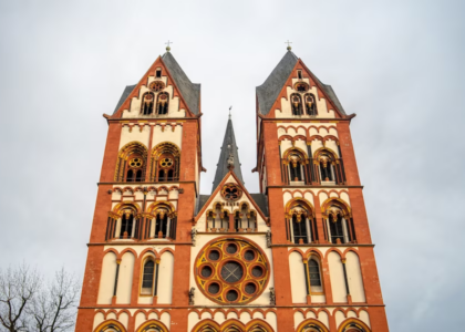 Limburg Cathedral bathed in sunlight against a backdrop of clouds